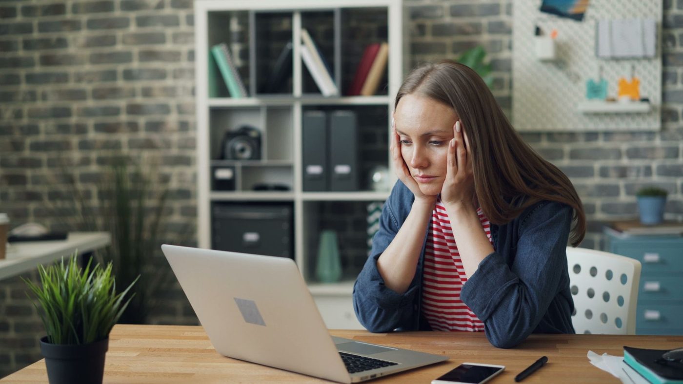 A business owner looking worried at her laptop screen