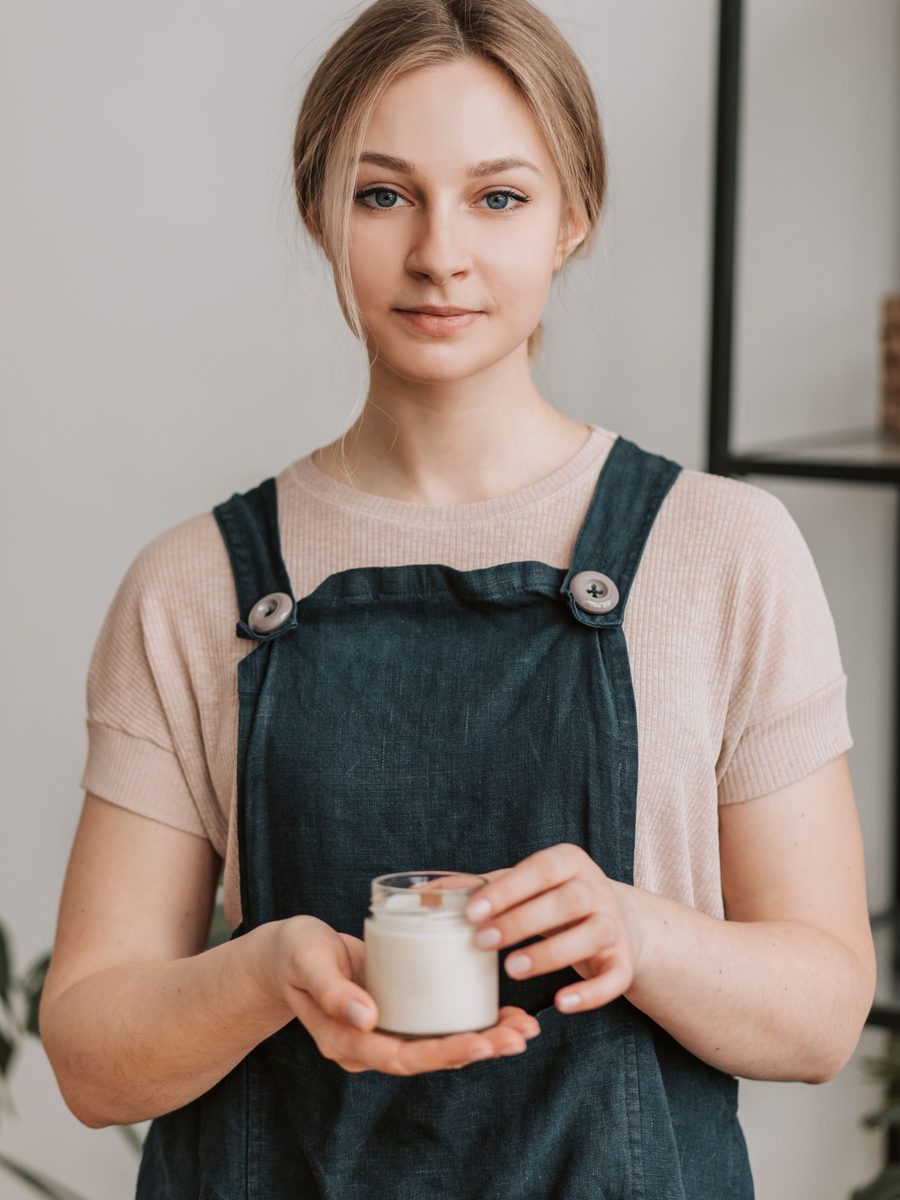 A small business owner holding one of her own handmade candles