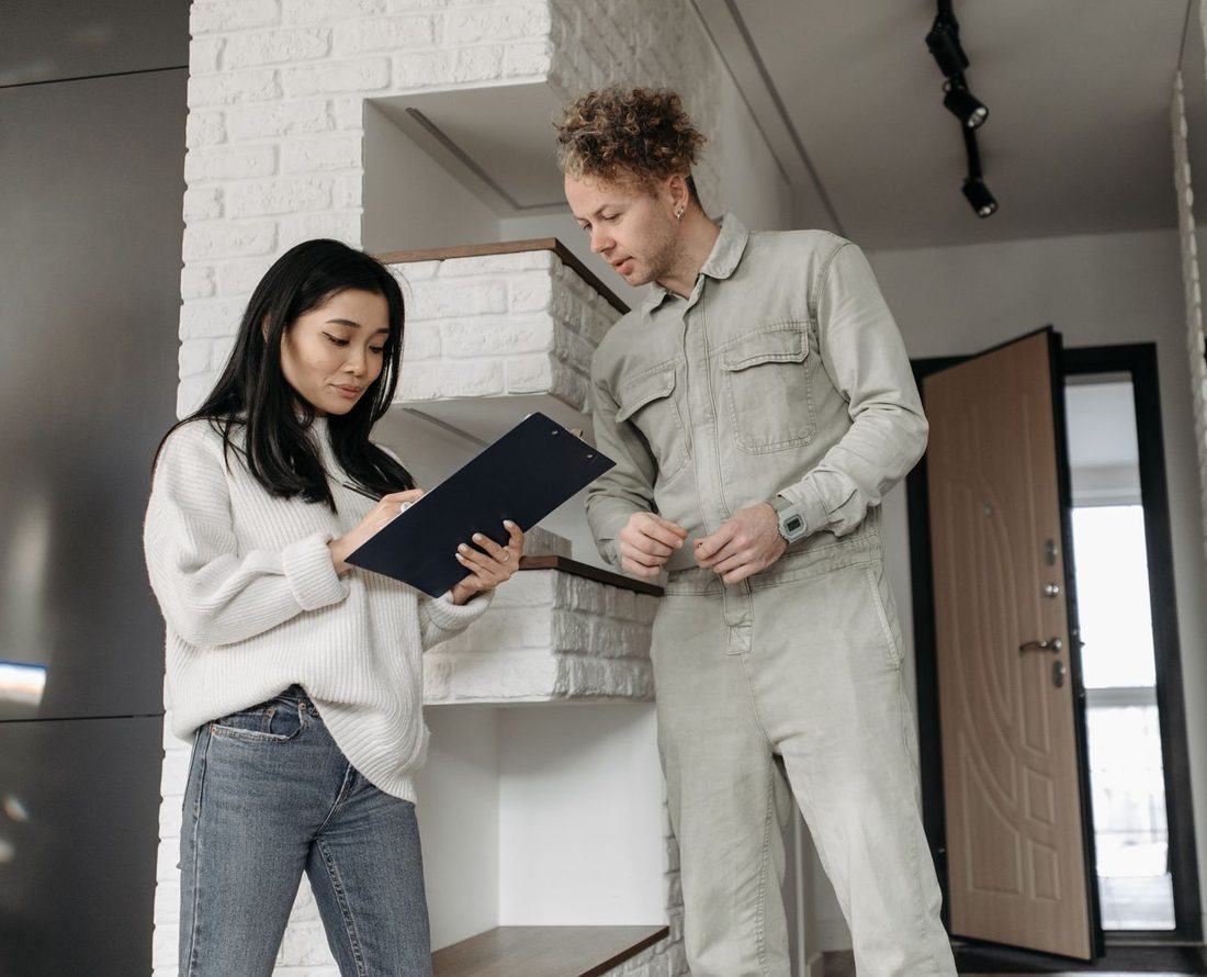 A customer reading a quote on a clipboard with a tradesman