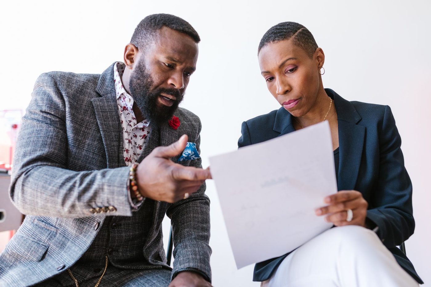 A business owner pointing out a clause to a colleague holding the document