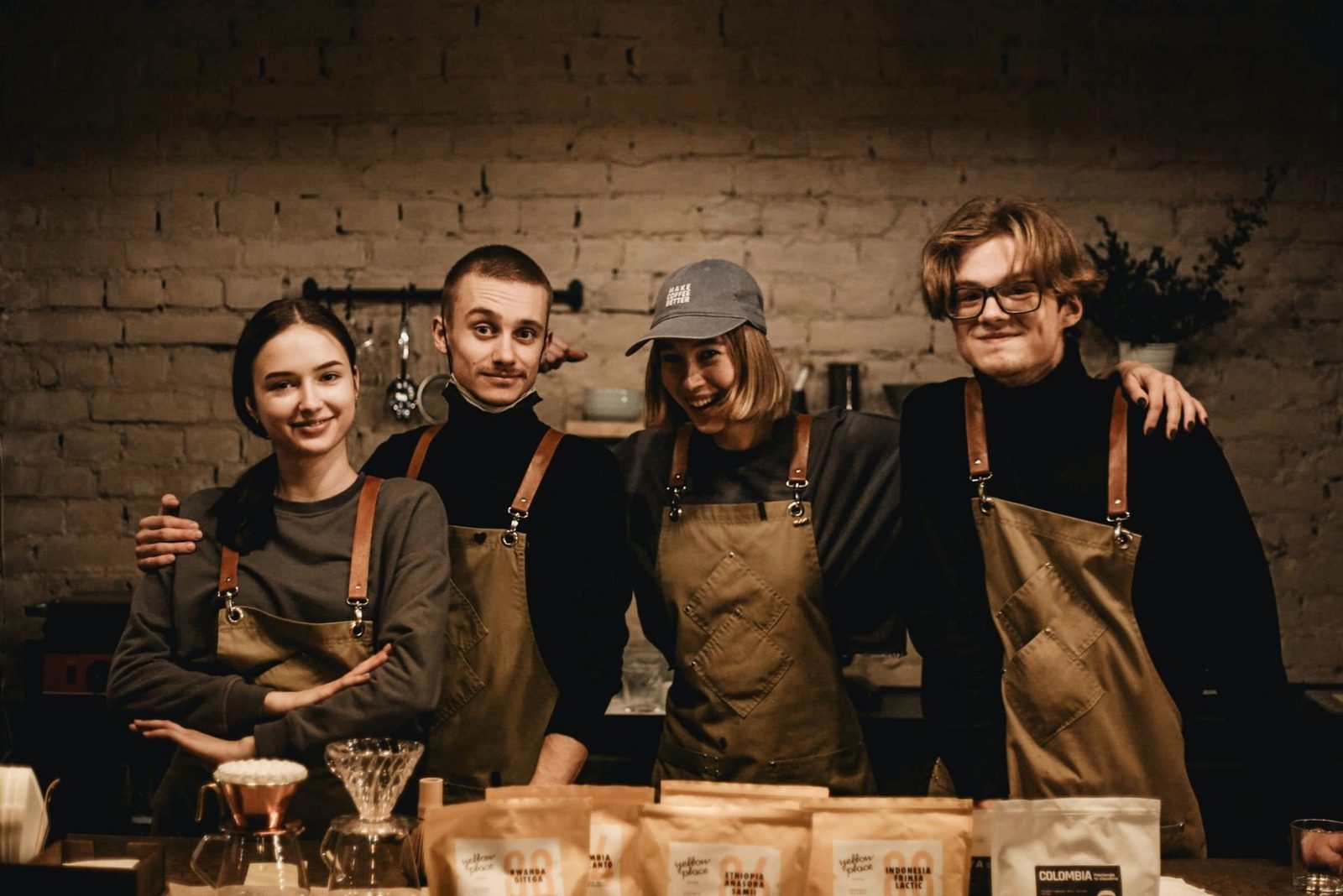 Four café staff in aprons behind their counter