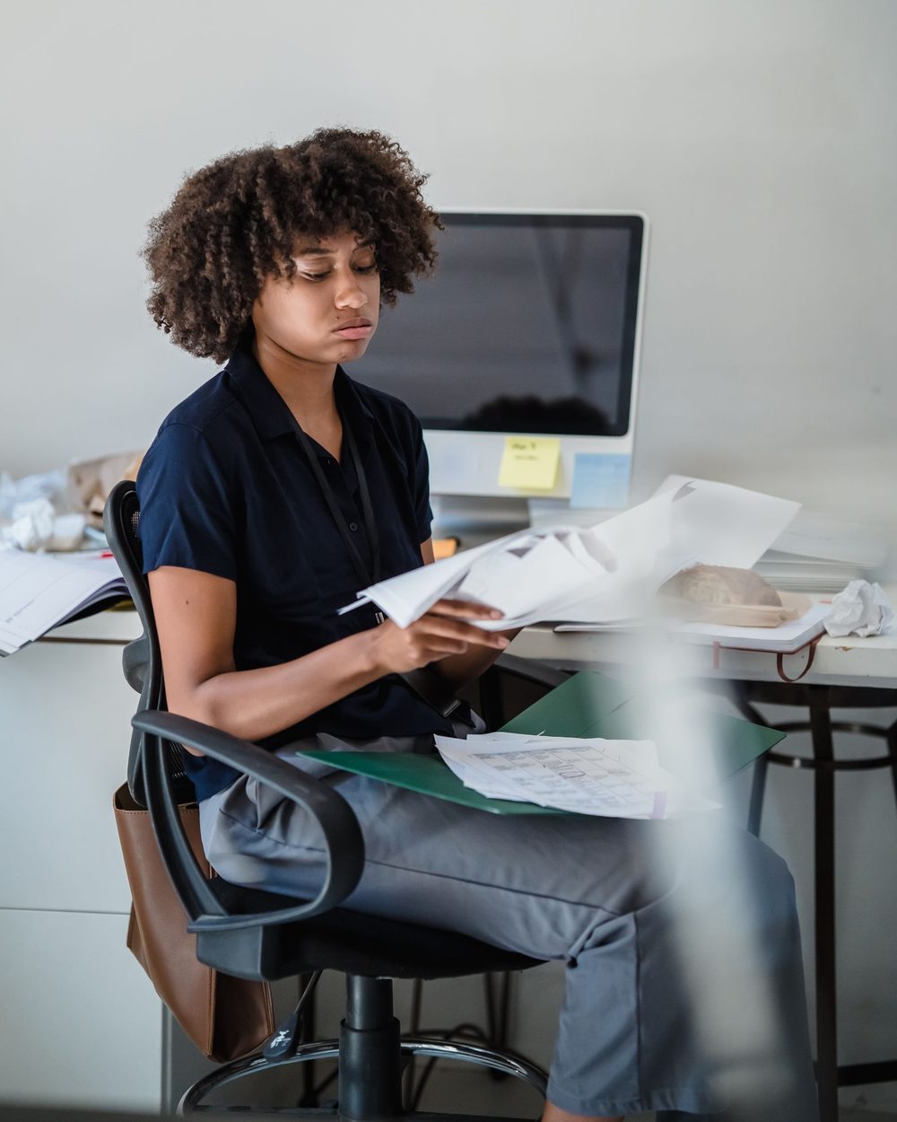 A manager at her desk going through a folder of papers