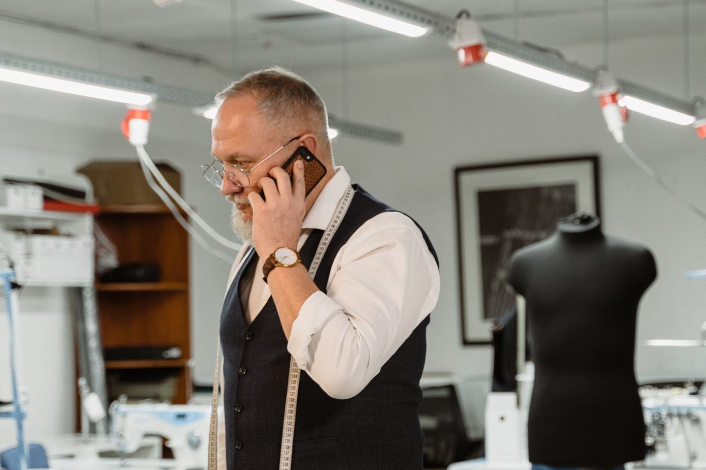 A tailor on the phone in his workshop