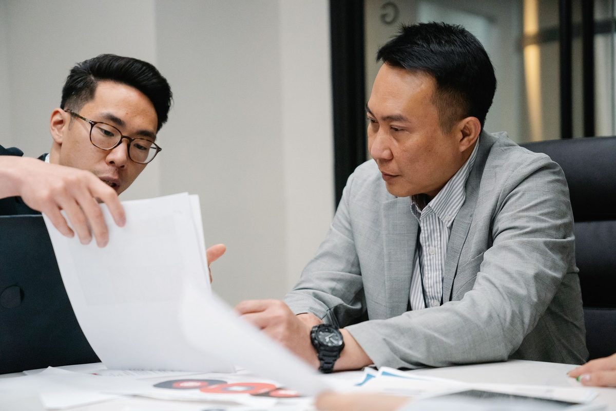 Two colleagues going through printed documents at a meeting table