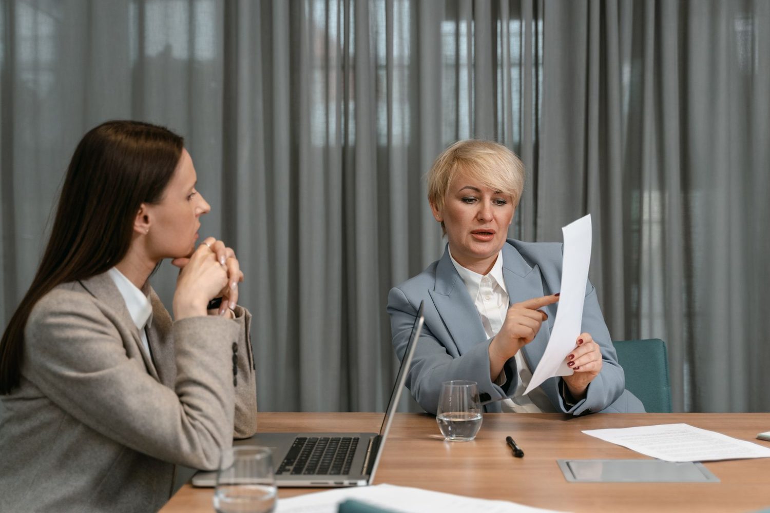 A manager going through a printed document with a colleague in a quiet one-to-one meeting
