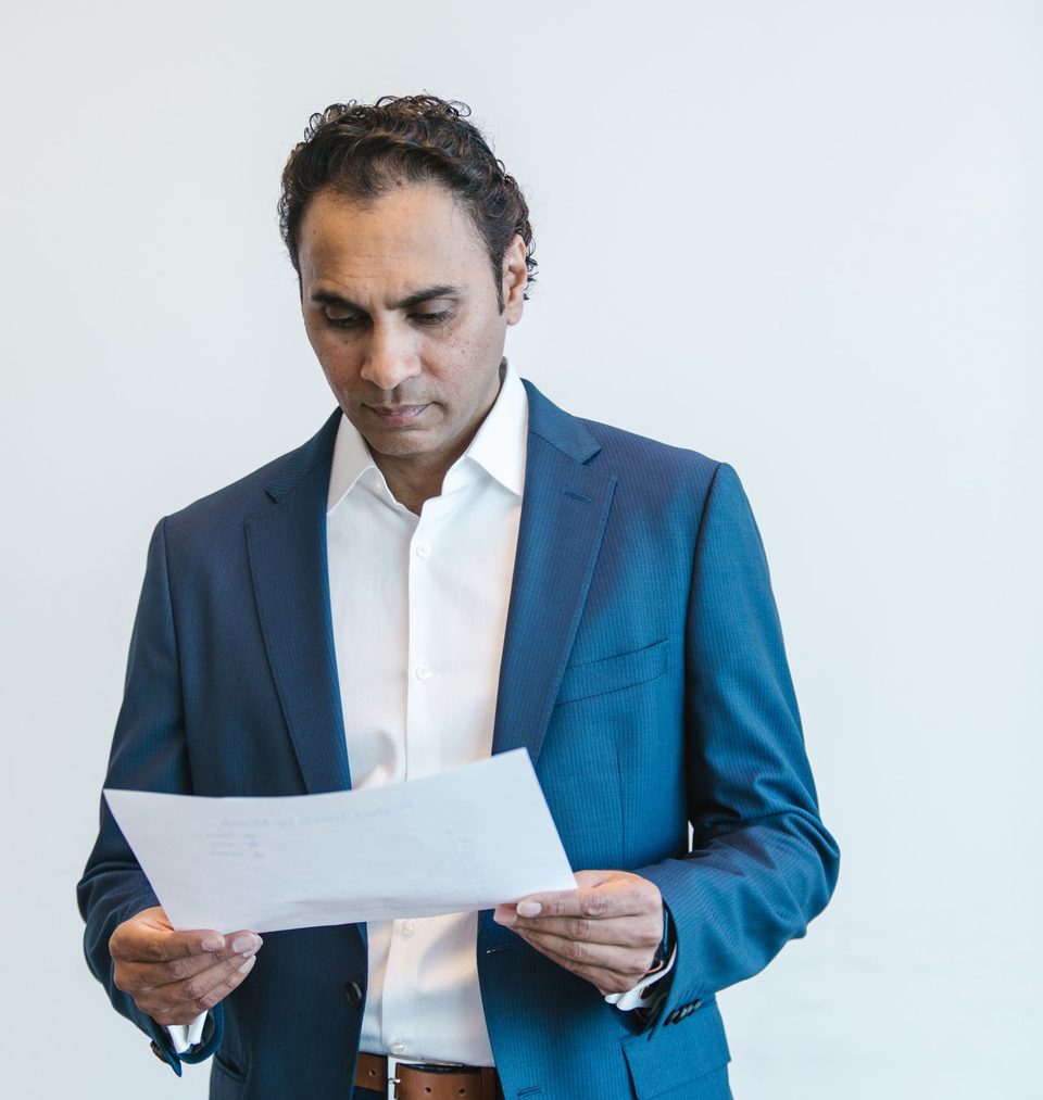 A manager in a suit reading a printed page