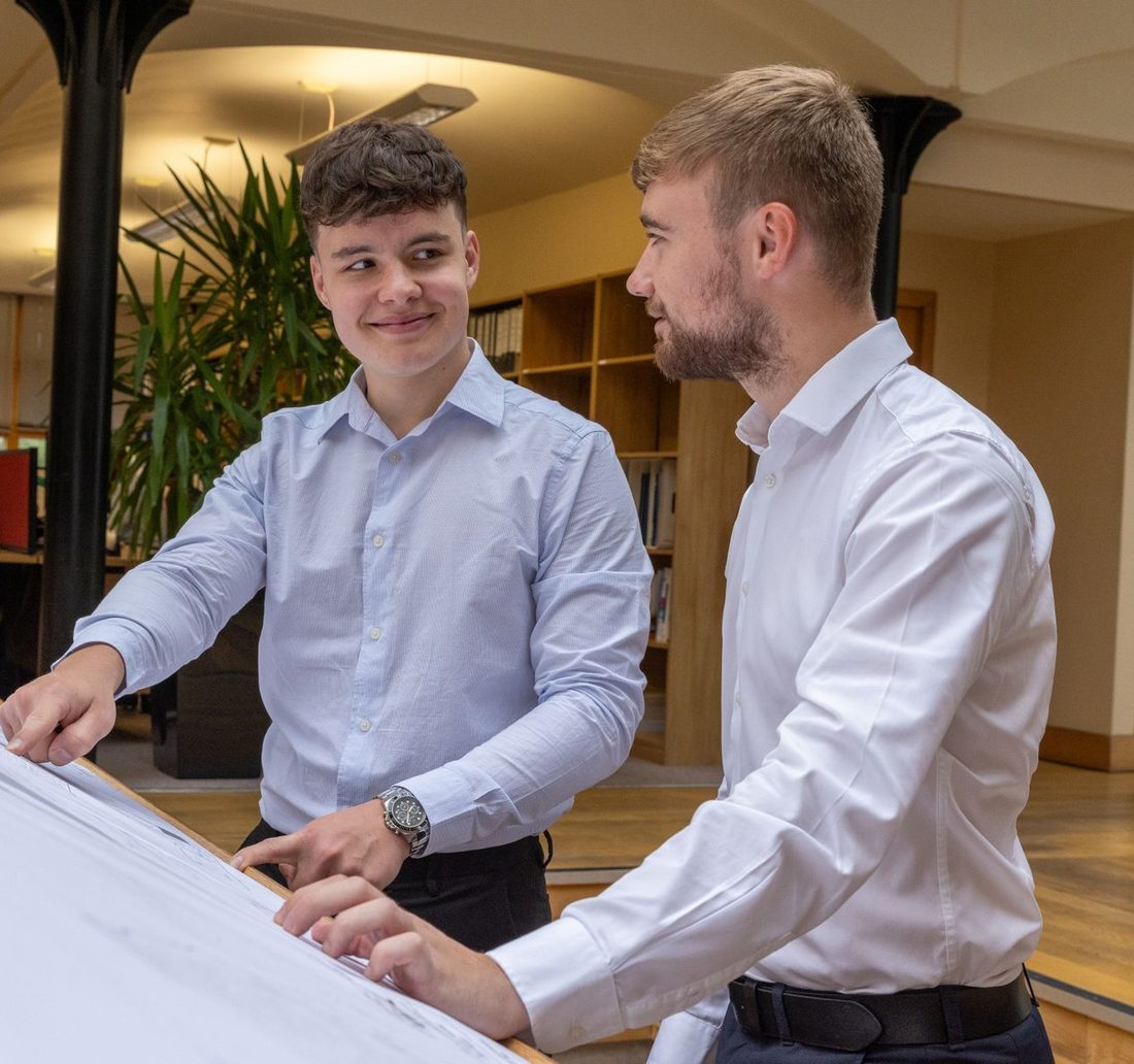 Two business partners going through plans together in their office