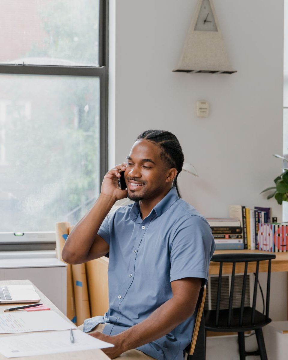 A business owner on the phone at his desk, smiling