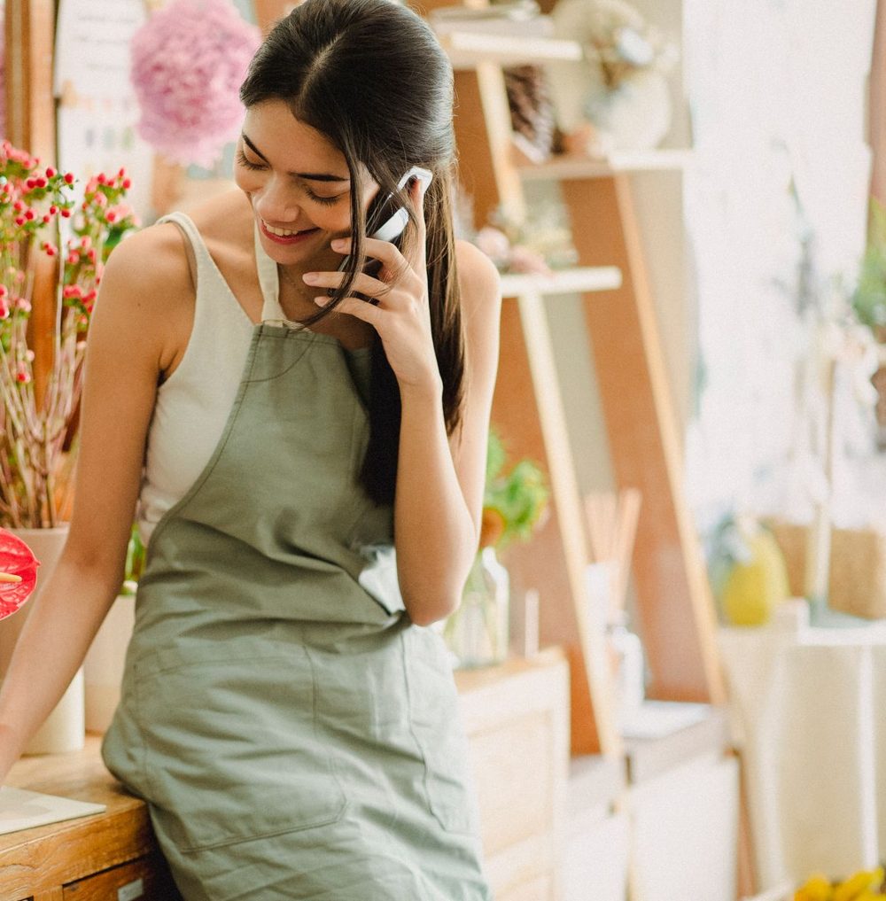 A florist taking a call in her shop