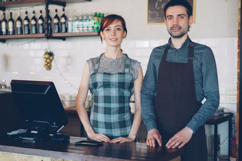 Two business owners behind the counter of their cafe